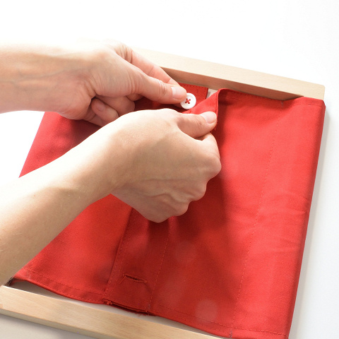 Montessori-Anziehrahmen mit kleinen Knöpfen.