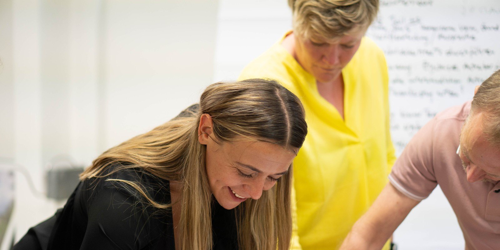 Teilnehmende der Coaching Ausbildung arbeiten in einer Kleingruppe zusammen